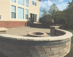 Curved seating wall enclosing the deck and firepit.